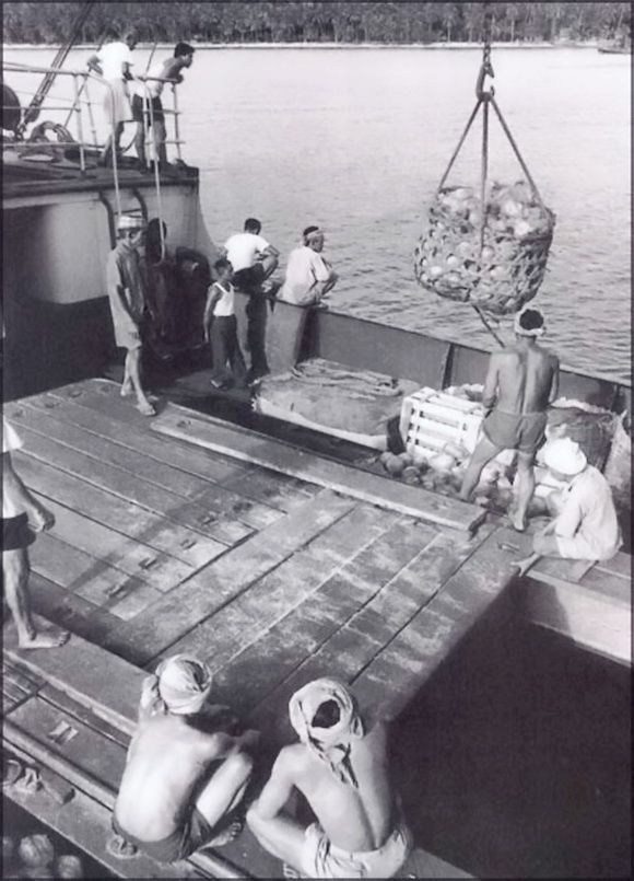 A group of men on a boat loading a cargo.